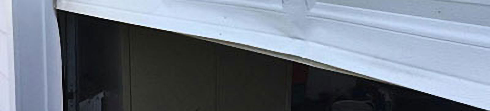 Dented and misaligned white sectional garage door derailed and stuck at a Cicero, IL home.