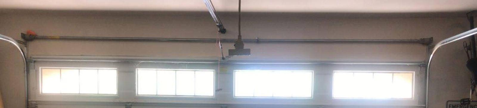 Wide view of white sectional garage door with new tracks and cables installed in a Burbank, IL residential garage.