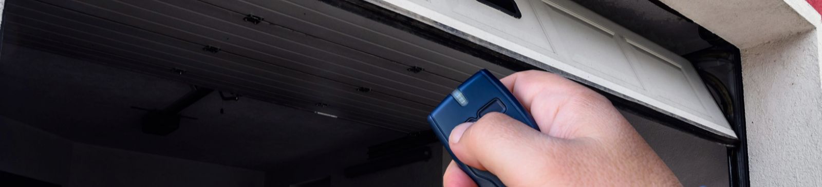 Hand holding a remote to open a garage door – Contact Garage Door Repair Chicago for fast and reliable service
